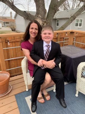Duchenne and celebration | Muscular Dystrophy News | Columnist Betty Vertin and her son Charlie are all smiles as they pose on the back deck after Charlie's confirmation. Charlie is decked out in slick black suit and tie, his mom in a pretty dress and sandals.