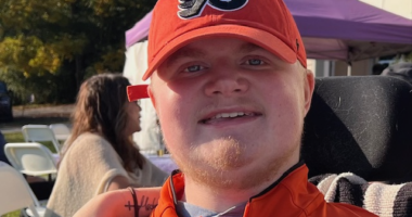 A close-up photo shows a man wearing a Philadelphia Flyers baseball cap.