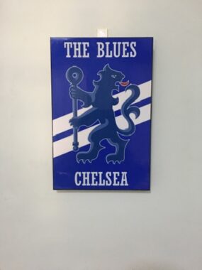 A photo of a blue plaque with the Chelsea Football Club logo and the words "The Blues."